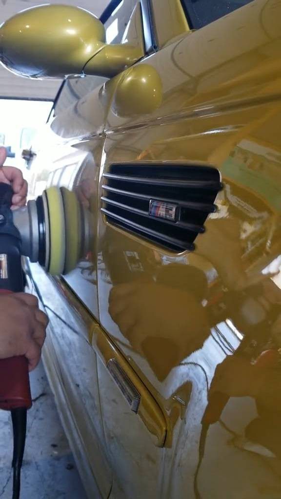 Technician machine-polishing yellow paint during a paint-correction service